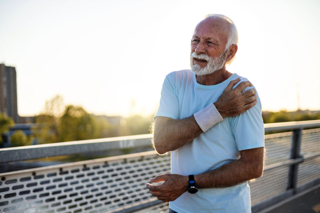 Senior men with shoulder pain. Senior man suffering with shoulder pain during workout.