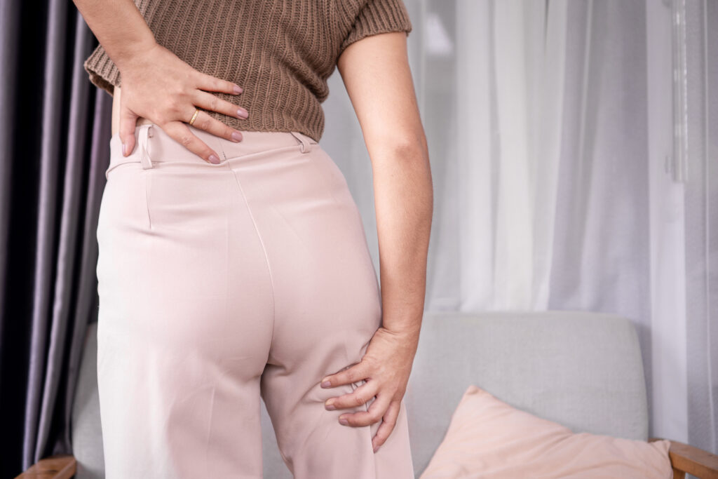 Sciatica concept with woman feeling nerve pain from lower back and goes down to legs.