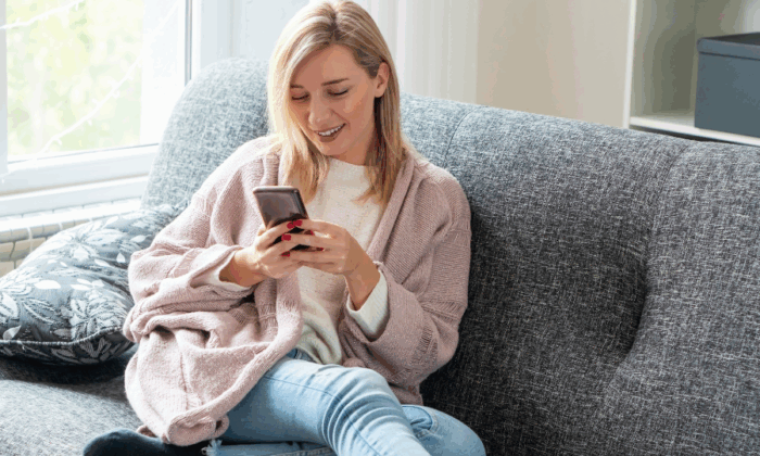 Woman using smartphone on sofa