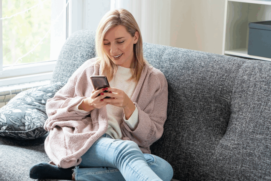 Woman using smartphone on sofa