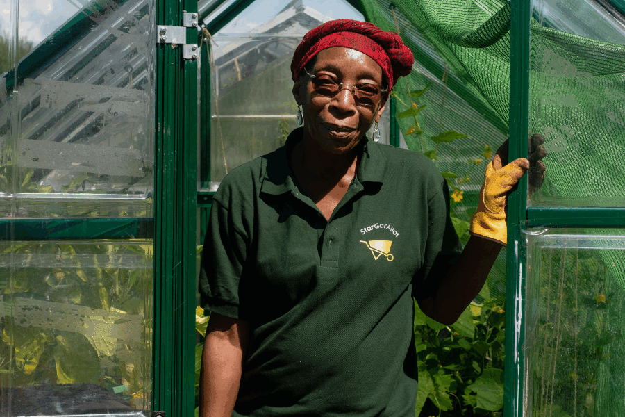 Woman standing in door of greenhouse looking at camera