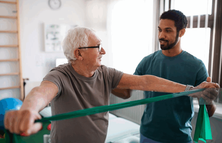 Older man using band to exercise with physio