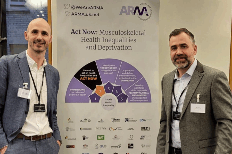 Nick Livadas and Hal Brace in front of banner